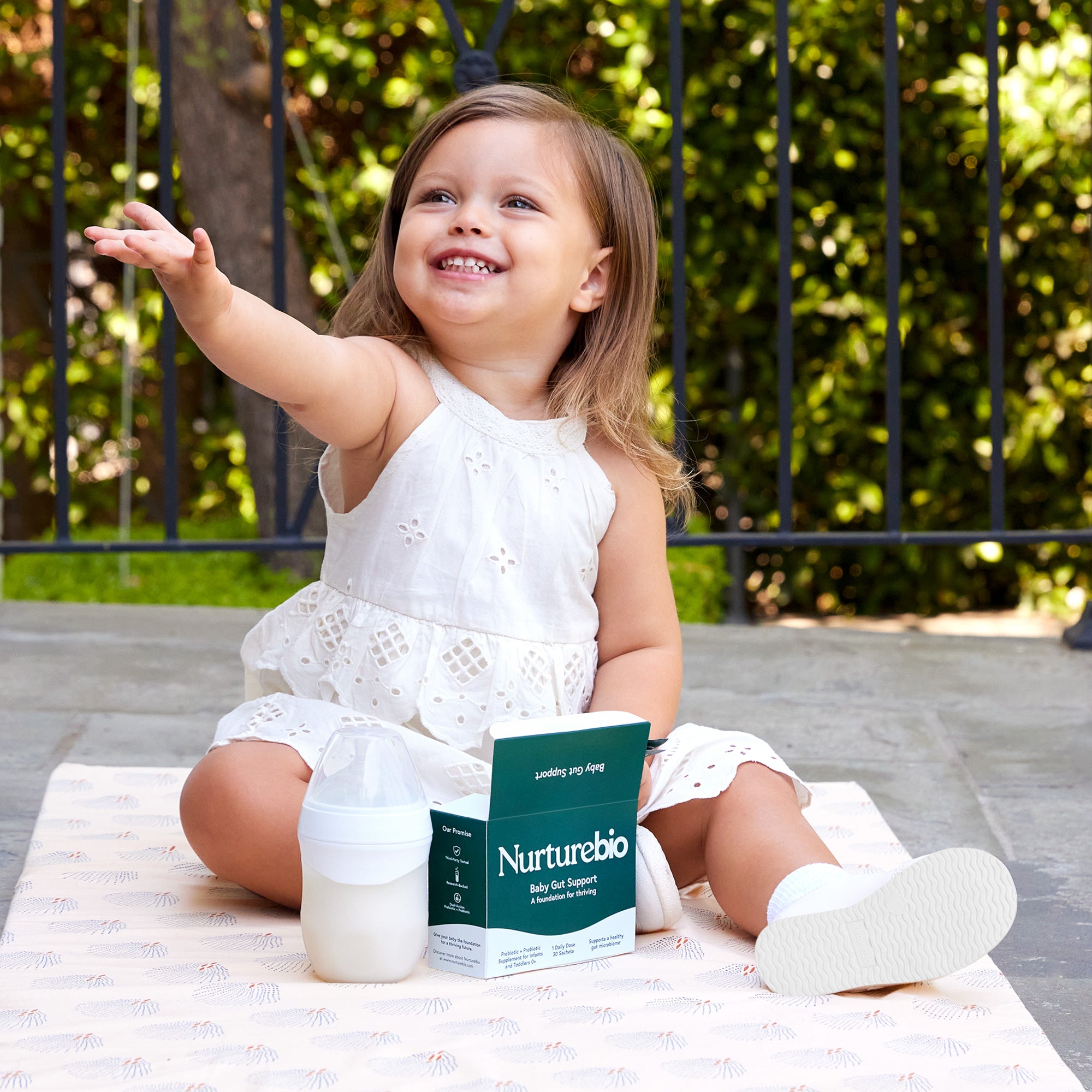 Child holding a Nurturebio product outdoors