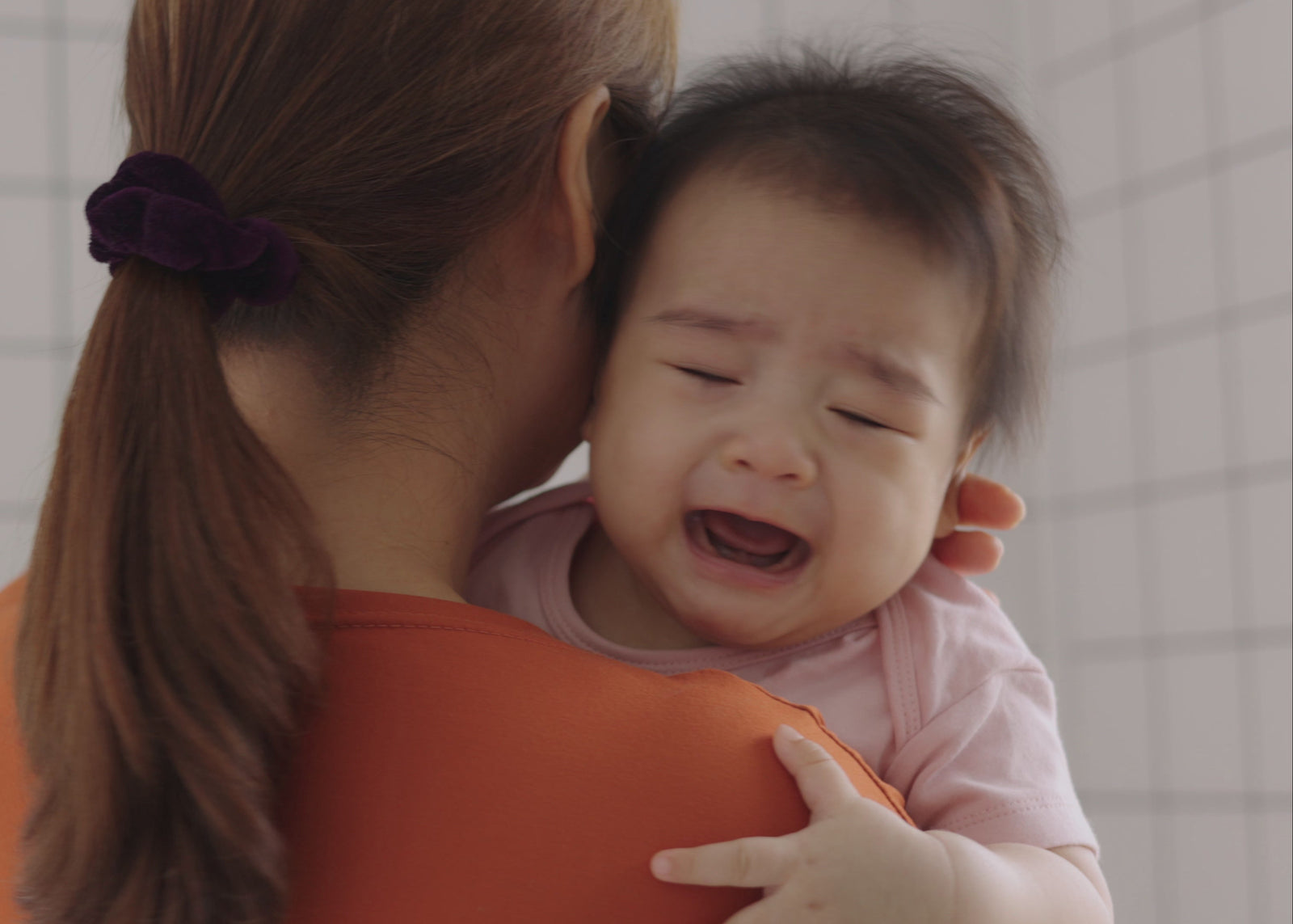 mother holding a crying baby